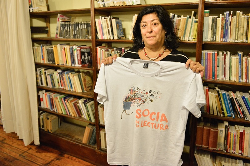 Almudena Grandes sostiene una remera de Socios de la lectura